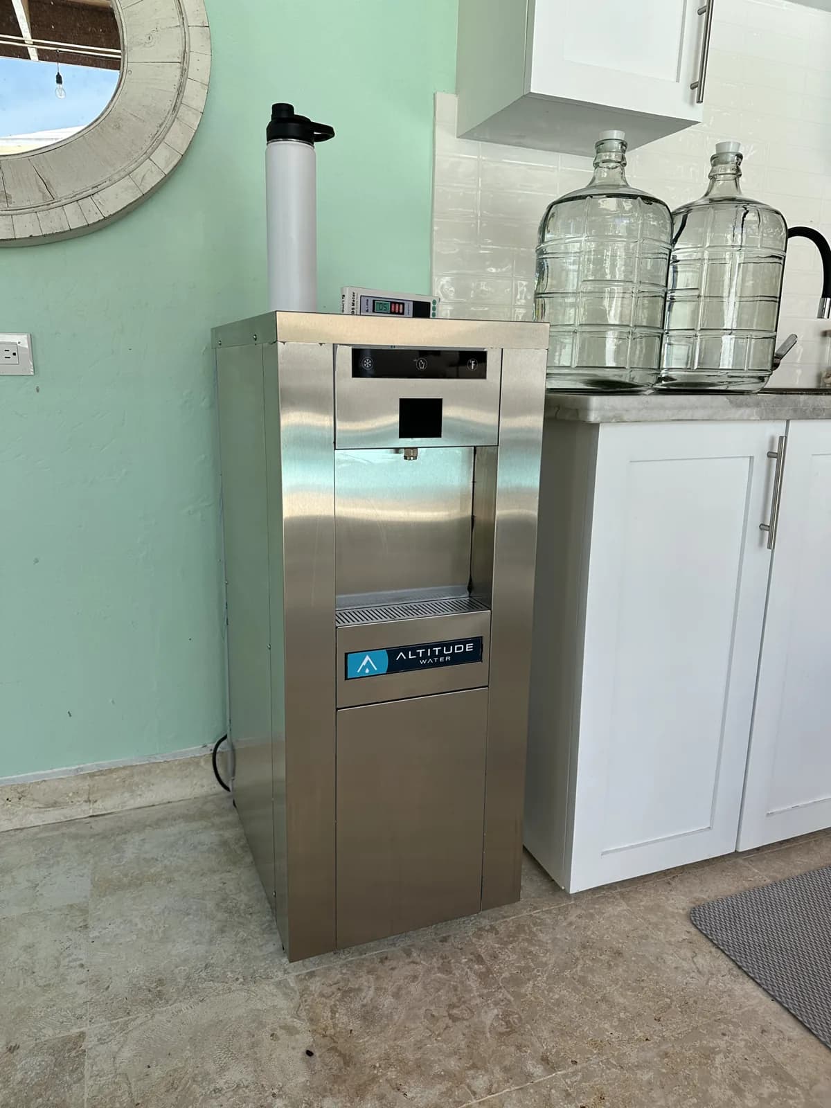The installed T-12 beside the cabinet, with glass 5-gallon bottles next to it.
